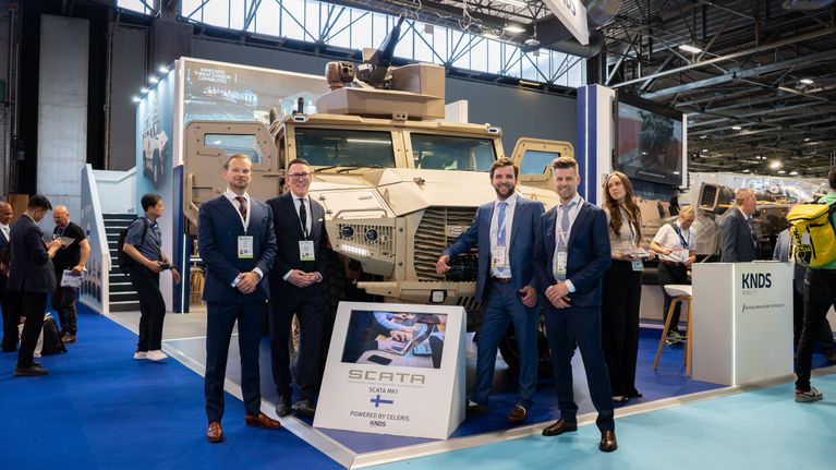 Neljä miestä puolustusalan Eurosatory-messuilla panssariauton edustalla.