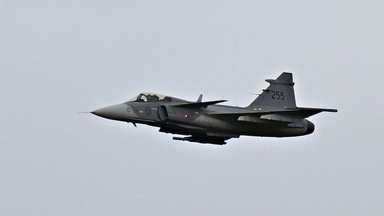 Saab Gripen E-sarjan hävittäjälentokone lentää pilvisellä taivaalla.