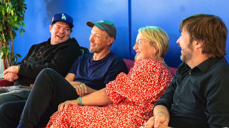 Juuso Myllyrinne, Mikko Peltsi Peltola, Satu Kurvinen ja Juha Lahti istuvat nauravaisina Radio Suomen sohvalla.