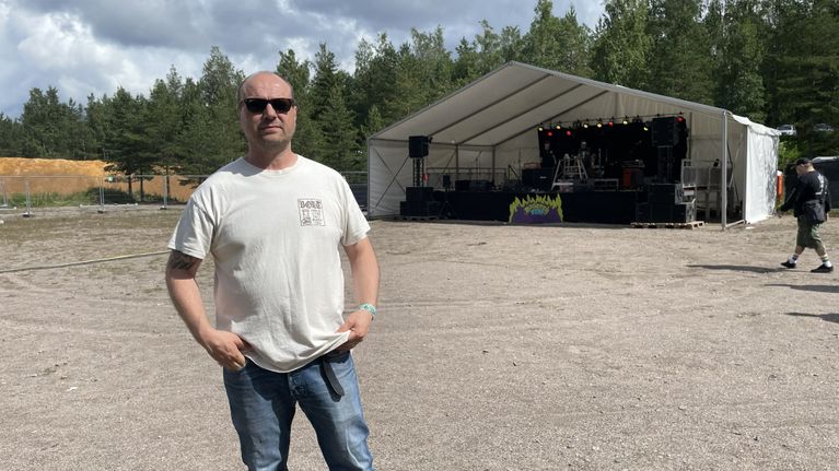 Rooster Festien jätjestäjä Antti Sirvo seisoo festarikentällä. Taustalla näkyy päälava.