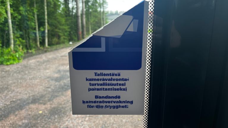 Bussin ikkunassa on tarra, jossa lukee suomeksi ja ruotsiksi kameravalvonnan turvallisuussyistä.
