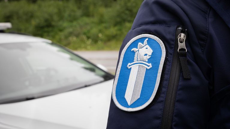 Poliisin logo ylikonstaapelin työasun hihassa.