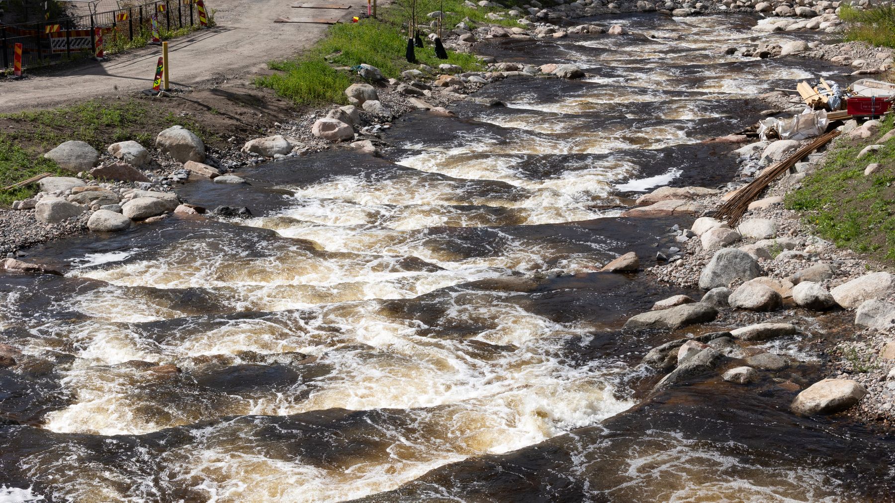 Vesi virtaa kuohuen Tourujoen uudessa porrasrakenteessa Jyväskylän Kankaalla.