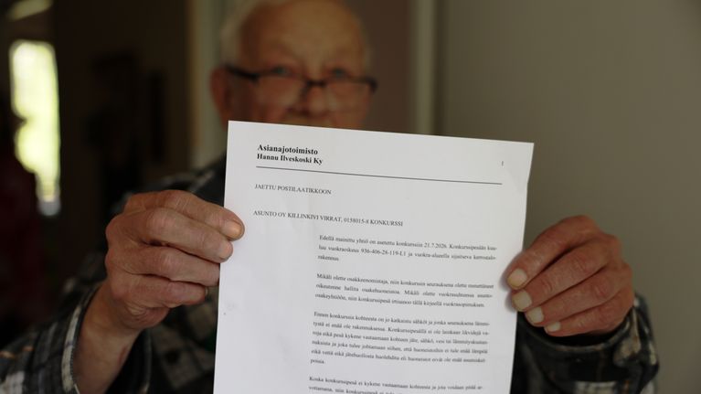 Mies näyttää asunto-osakeyhtiön konkurssipaperia.