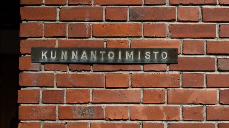 Säynätsalon kunnantalon tiiliseinässä on kyltti, jossa lukee "Kunnantoimisto".