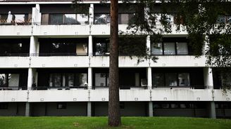 Kerrostalo, jossa useita parvekkeita ja ikkunoita, talon edustalla kasvaa puita.