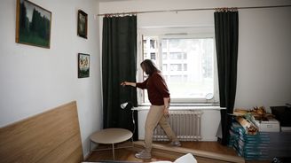 Henkilö seisoo makuuhuoneessa ikkunan edessä.