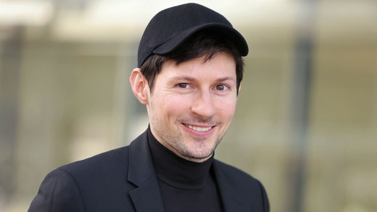 Pavel Durov pukeutuneenä mustaan pukuun, mustaan lippikseen ja mustaan poolopaitaan, jossa on valkoinen nuolikuvio.