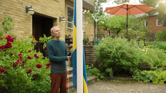 Felix Herngren eli hammaslääkäri-Alex nostaa Ruotsin lippua salkoon.