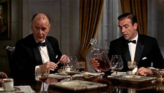 Eversti Smithers (Richard Vernon, vas.) opastaa James Bondin (Sean Connery) Kultasormen jäljille.