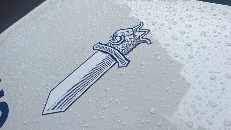 Poliisin miekkaleijonan kuva poliisiauton konepellissä.