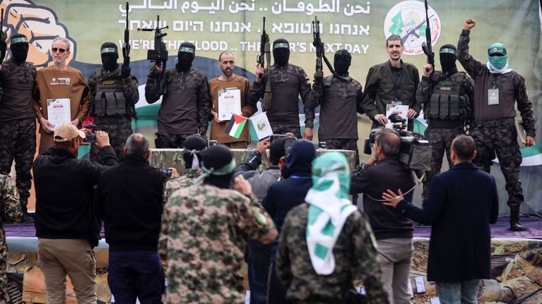 Kolme israelilaispanttivankia Hamasin taistelijoiden kanssa lavalla.