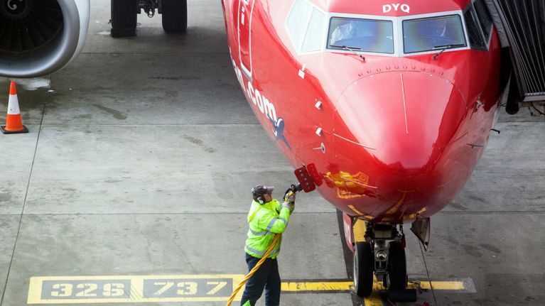 Lentoaseman työntekijä huoltaa Norwegian-lentoyhtiön konetta.