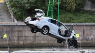 Valkoista autoa nostetaan Aurajoesta. Auton etuosa on vaurioitunut.