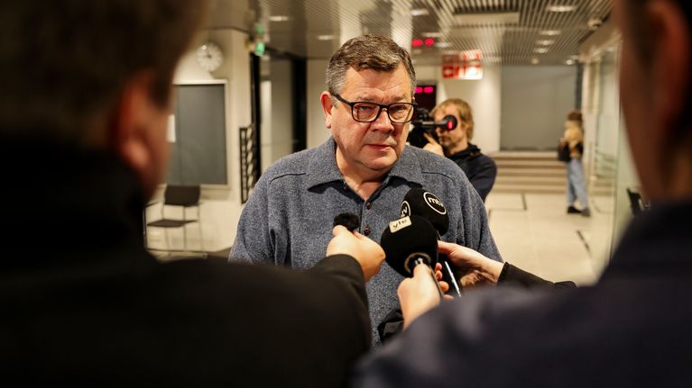 Jens Ihle seisoo toimittiajien edessä, jotka ojentavat tätä kohti mikrofoneja (yle ja MTV).