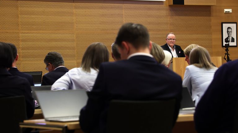 Salon valtuusto istuu valtuustosalissa. Mies puhujanpöntössä.
