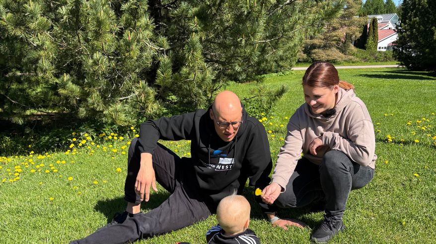 Uimari Matti Mattsson, Maiju Mattsson ja Pyry leikkivät nurmikolla Porissa.