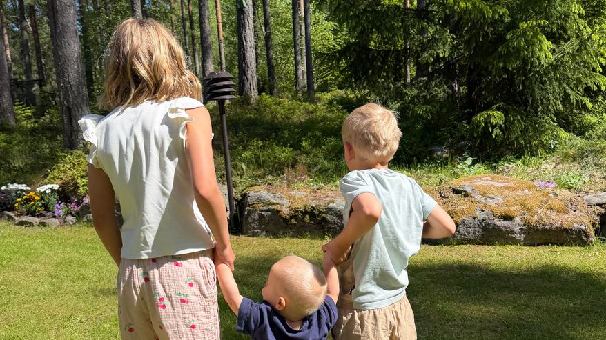 Uimari Matti Mattssonin lapset Varpu (vas.), Pyry ja Aarni nurmikolla.