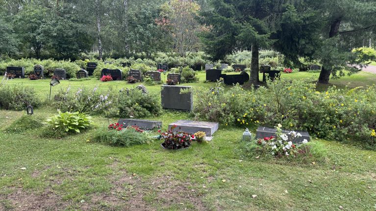 Hautausmaa, jossa edustalla kolme kaadettua hautakiveä. Kuvan reunassa näkyy vääntynyt hautalyhty.