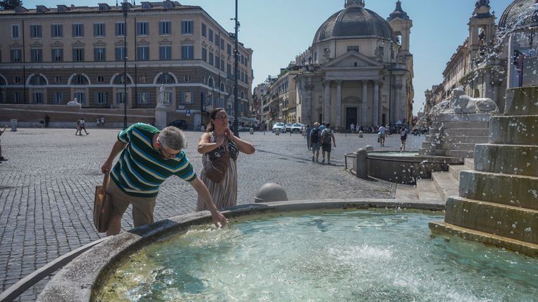 Italian pääkaupungissa Roomassa turistit viilensivät itseään suihkulähteessä helleaallon aikana.