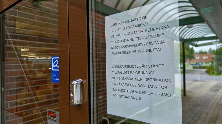 Kirjaston oveen laitettu ilmoitus kirjastossa sattuneesta vesivahingosta.