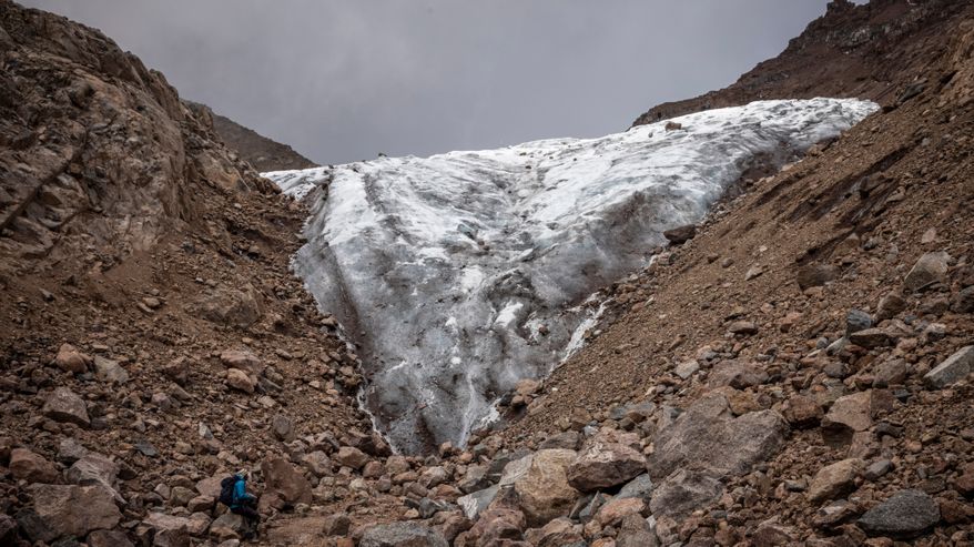 Vuorikiipeilijä tummuneen jäätikön juurella Mount Kenyalla.