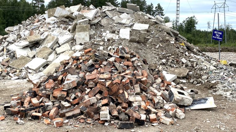Korkea kasa käytettyjä isoja betonilaattoja ja pienempi kasa tiiliä.