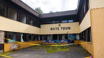 Tyhjillään olevassa laitoskiinteistössä sijaitseva airsoft-harrastajien harrastustila. Seinässä teksti Rate Town. 