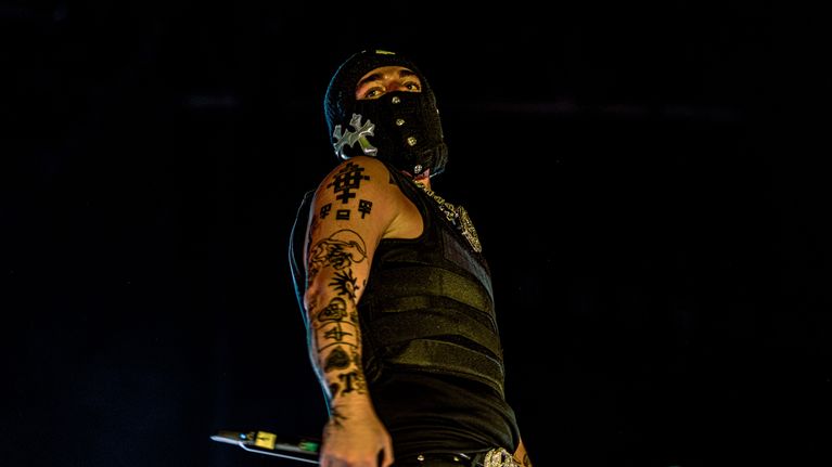 mies jolla koristeltu hiihtomaski katsoo kaukaisuuteen. rap artisti yeat.