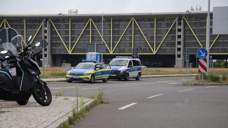 Kaksi poliisiautoa pysäköitynä Leipzig/Hallen lentokentän edustalle.