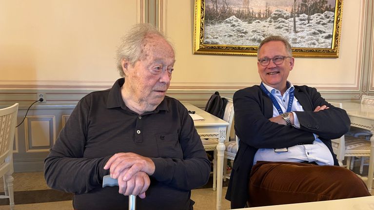 Kaksi miestä istuu pöydän ääressä