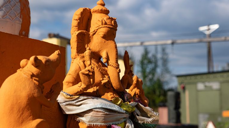 Oranssi Ganesha jumalan patsas, jossa ihmishahmolla on norsun pää.