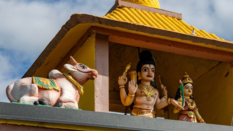 Temppelin katolla on värikkäitä hahmoja: Pyhä lehmä, Shiva jumala ja hänen vaimo Parvati.