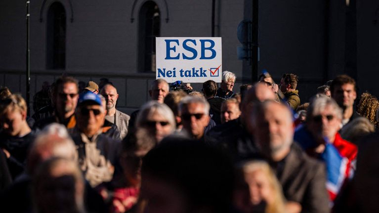 Joukko ihmisiä seisoo ulkona, keskellä kyltti, jossa lukee "ESB Nei takk" ja punainen ruksi.