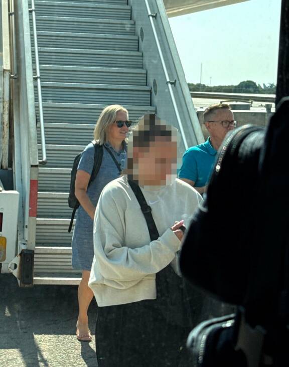 Turistivirran mukana! Riikka Purra ja puoliso Mikko Välimaa astelivat koneesta Kreetan lämpöön muiden matkustajien seassa rennossa lomavarustuksessa.