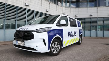 Poliisin pakettiauto valkoisella pohjavärillä ja poliisin teksti- ja heijastinteippauksilla.