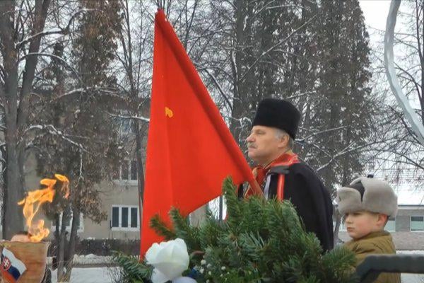 Slovenská a sovietska hymna prehlušovaná zvukmi pyrotechniky, čestná stráž a školák v uniforme a s červenou zástavou s kosákom a kladivom. | Nie, to nie je rok 1976 počas ruskej okupácie, ale rok 2026 so Slovenskom v Európskej únii.