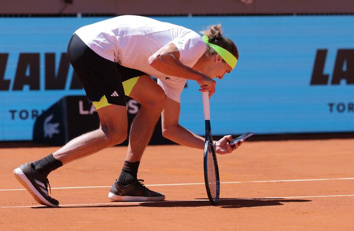L’Allemand Alexander Zverev prend une photo avec son portable de la marque de la balle sur le court après avoir contesté la décision de l’arbitre, le 27 avril 2025.