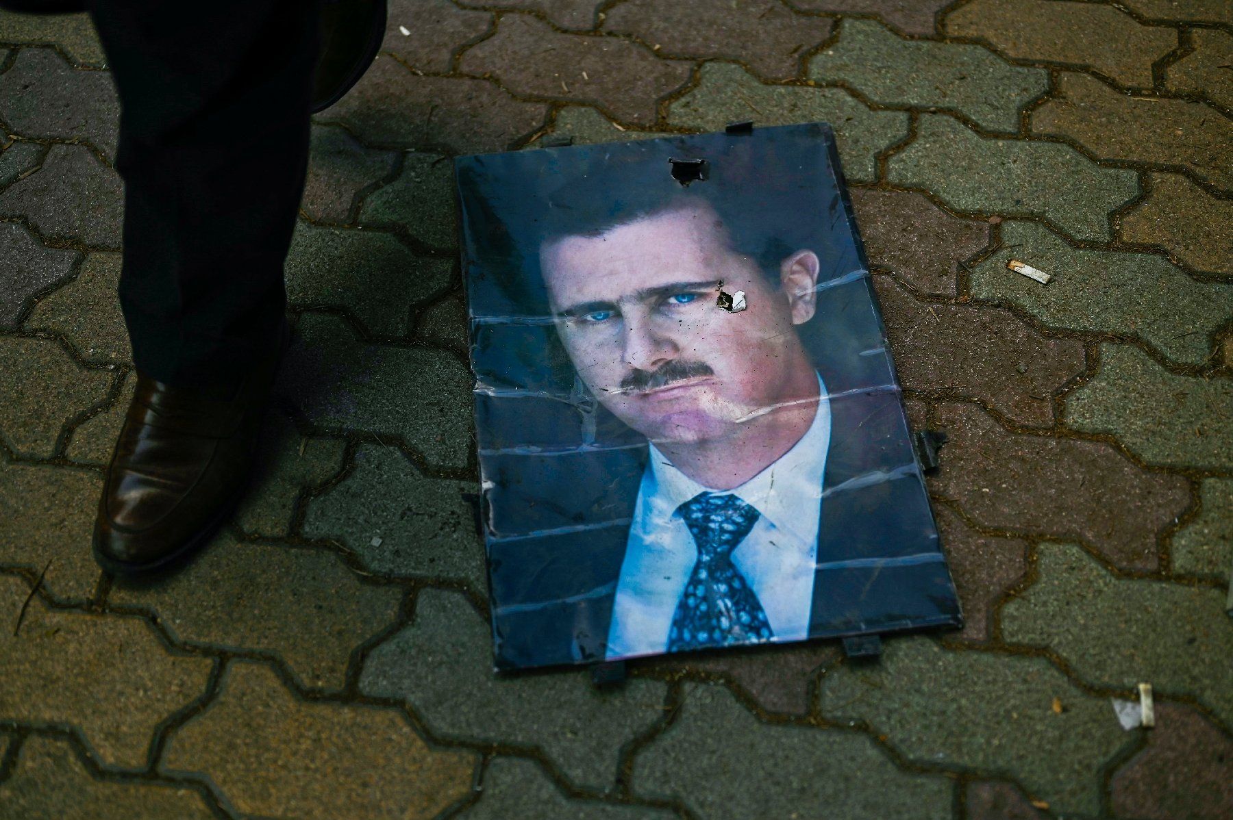 Portrait du président déchu Bachar al-Assad sur le sol le 13 décembre 2024, à Alep, en Syrie