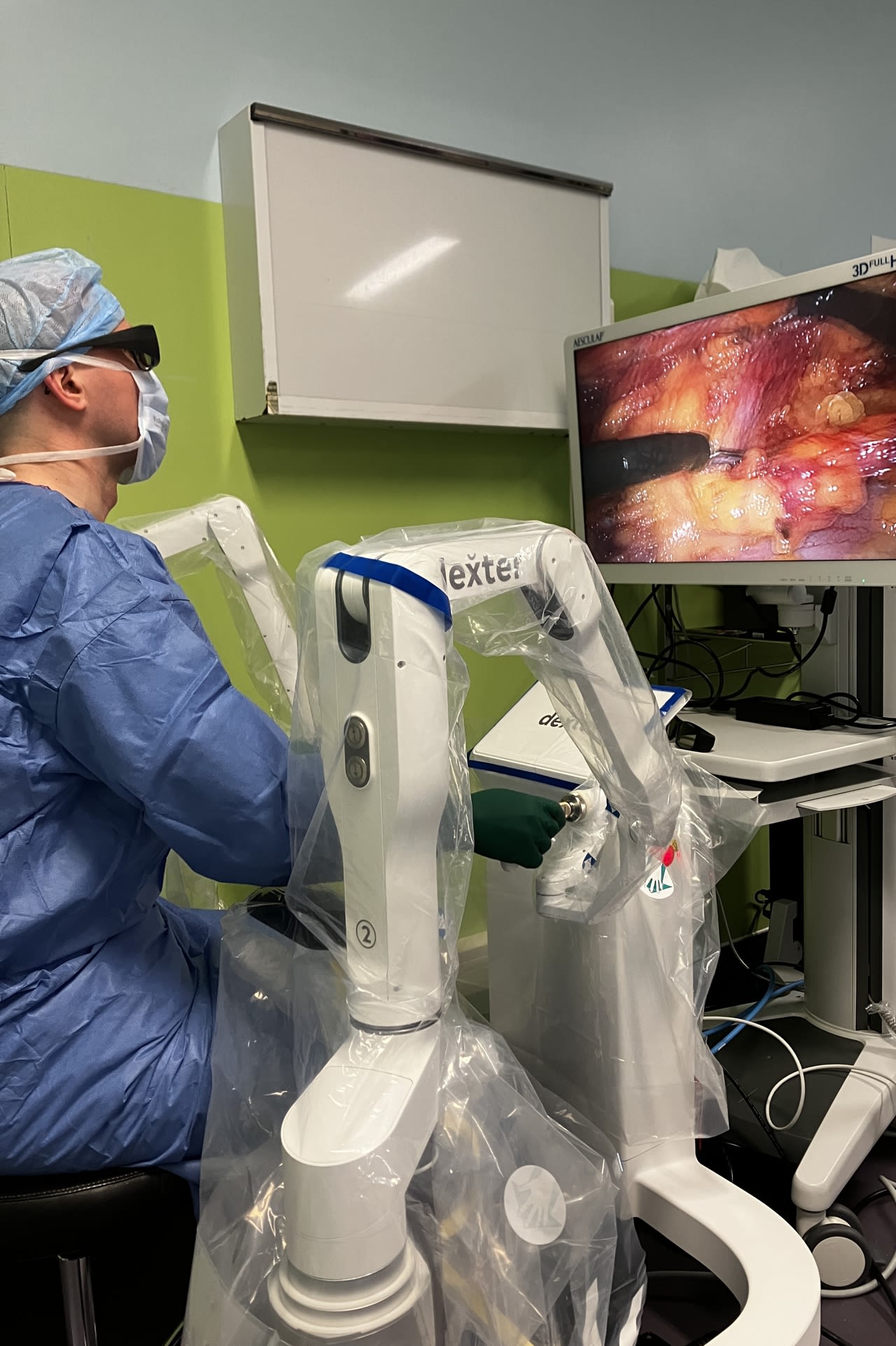 Le chirurgien manipule les bras articulés depuis sa console, en suivant ses gestes avec une vue en 3D de l’intérieur du patient.