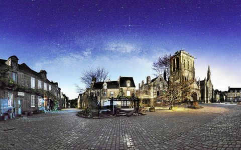 Après minuit, la place du village de Locronan est déserte. Éclairés par un quartier de lune, les bâtiments sont bien lumineux tandis que la voie lactée est éclatante.