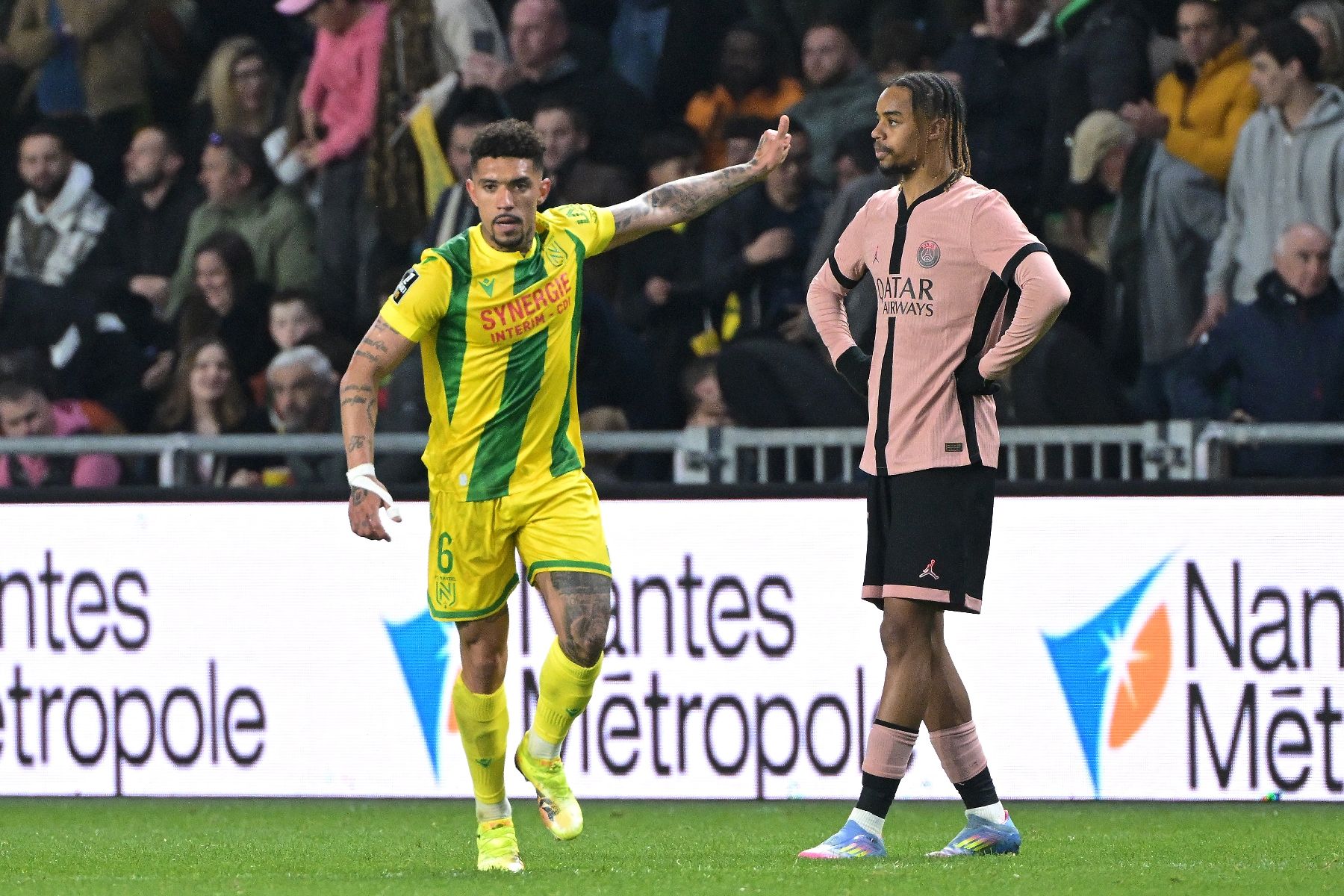 Le Brésilien de Nantes Douglas Augusto (g) auteur du but égalisateur face au Paris SG de Bradley Barcola (d) (1-1), le 22 avril 2025 au stade de la Beaujoire de Nantes