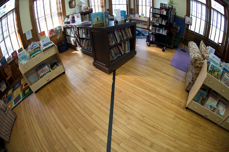 La frontière américano-canadienne matérialisée par un ruban noir à l’intérieur de la Haskell Free Library and Opera House, dans le Vermont et au Québec. (photo prise en 2017)