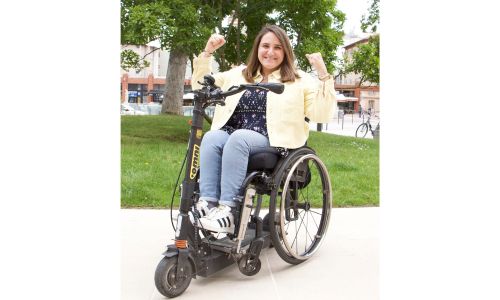 Charlotte Alaux sur sa trottinette Omni, levant les coudes en signe de victoire.