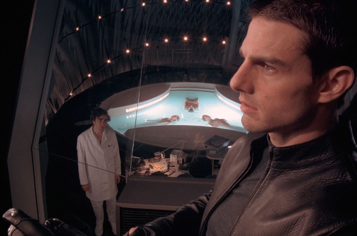 Scène du film Minority Report avec un homme en veste noire observant un bassin éclairé, 2002.