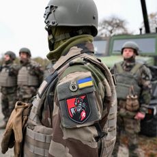Des soldats ukrainiens de la 155e brigade mécanisée séparée se tiennent à côté de véhicules militaires lors d'un exercice d'entraînement de l'armée française au camp militaire de Mourmelon-le-Grand, le 14 novembre 2024