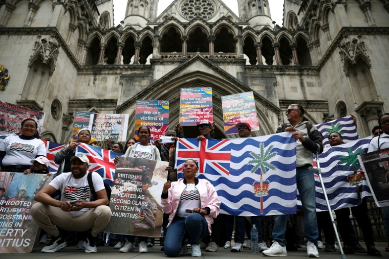 Des membres de la communauté chagossienne sont rassemblés devant la Haute Cour de Londres pour protester contre la signature de l'accord de restitution par le Royaume-Uni des îles Chagos à Maurice.  ( AFP / HENRY NICHOLLS )