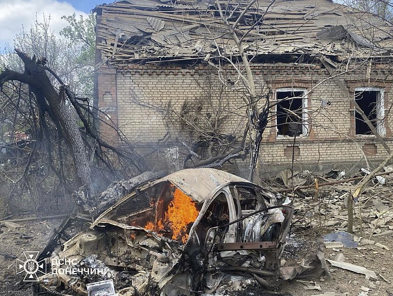 Une voiture en feu devant une maison détruite par un raid aérien russe dans la région de Donetsk, le 28 avril 2025.