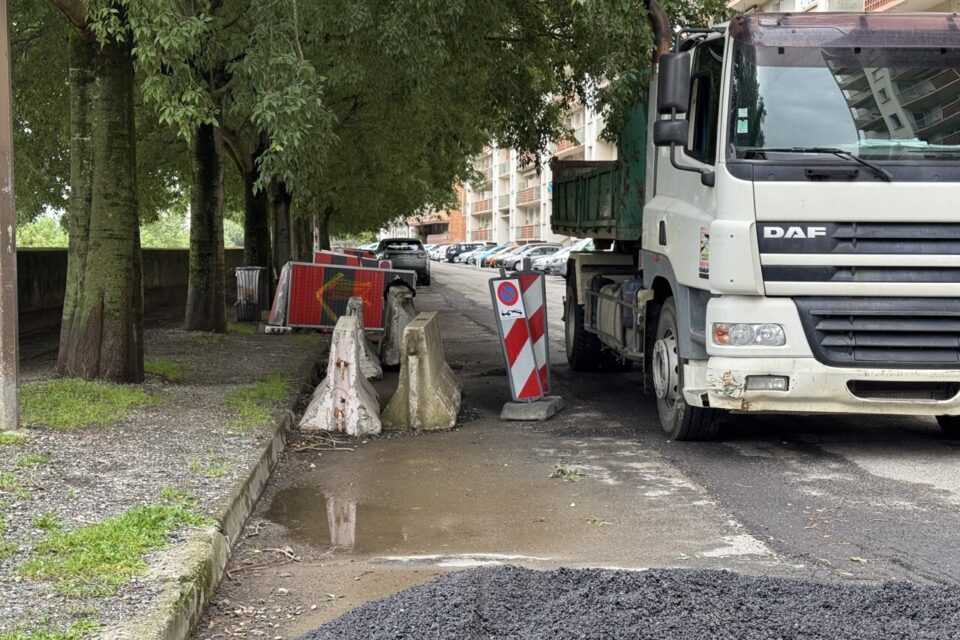 Les places de parking, anciennement à l'emplacement des barrières sur la photo, vont être supprimées à terme pour laisser place à la piste cyclable du REV 3