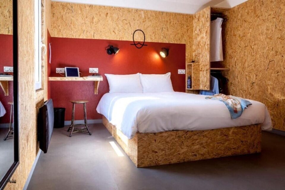 Voici un exemple des chambres refaites, à l'image de l'Hôtel Moustache : murs et meubles en bois, épurés, meubles chinés, nombreuses prises e courant et espace optimisé.